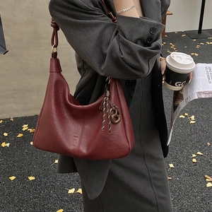 Deep red hobo bag with knotted shoulder strap for women, stylish tote in office setting