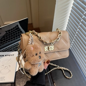 Quilted beige chain crossbody bag with plush puppy pendant and gold-tone twist lock