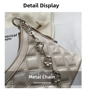 Detail of beige quilted leather bag with elegant flower-shaped silver metal chain strap