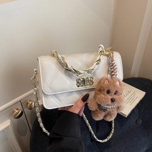 White quilted crossbody bag with gold chain strap and cute plush dog charm accessory