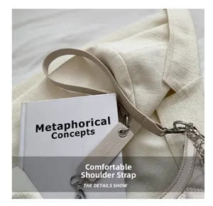Detail of comfortable beige leather shoulder strap with silver chain and metal buckle