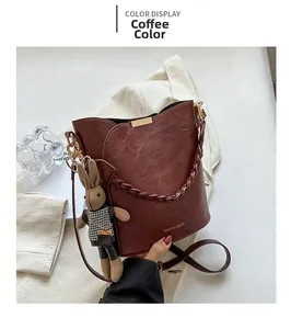 Détail d'un sac seau marron café avec charme lapin et texture cuir rétro
