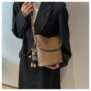 Détail du sac seau marron vintage avec poignée tressée et charm lapin mignon