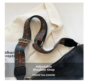 Détail du sac bandoulière en cuir noir avec large sangle vintage et boucle dorée