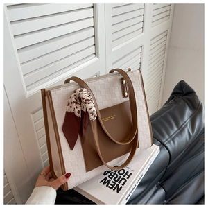 Detail of white checkered tote bag featuring brown trim and a stylish leopard print scarf