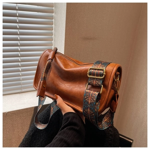 Vue détaillée du sac polochon marron avec bandoulière large à motifs géométriques