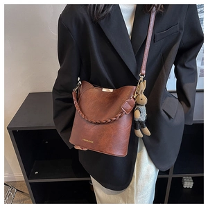 Détail du sac seau marron caramel avec poignée tressée et charm lapin personnalisé