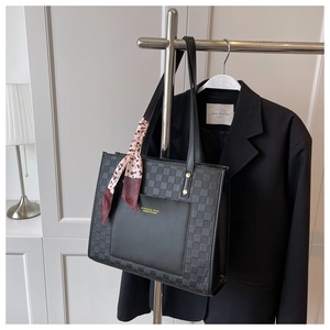 Detail of black tote bag with checkerboard pattern side and decorative floral scarf