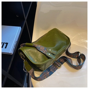 Détail d'un sac bandoulière vert vintage avec large sangle colorée aux motifs ethniques