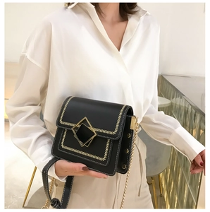 Détail du sac bandoulière noir avec fermoir doré et surpiqûres en chevrons