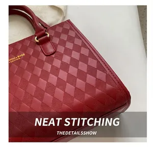 Detail of red quilted leather handbag showing precise stitching and gold metal hardware