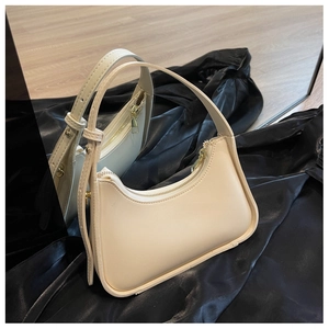 Detail-Spiegelansicht einer cremefarbenen Halbmodtasche mit goldenen Metallbeschlägen