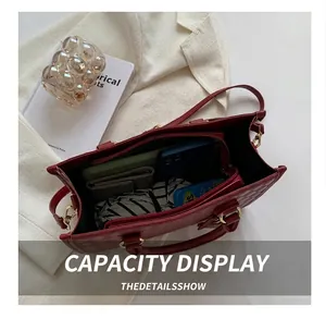 Detail showing the spacious interior compartments and red quilted texture of the handbag