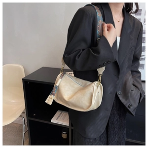 Détail du sac à bandoulière crème avec large sangle tissée colorée et fermoirs dorés
