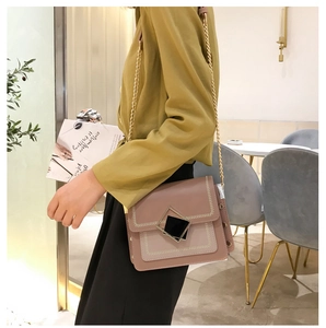 Détail du sac bandoulière rose avec motifs brodés et fermoir carré noir et doré