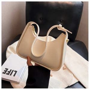 Detail einer cremeweißen Mondsichel-Achseltasche mit glattem Leder und Goldzipper