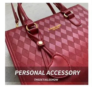 Detailed close-up of dark red quilted leather bag with heart charm and gold hardware