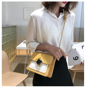 Détail du sac bandoulière en patchwork jaune et crème avec boucle géométrique dorée