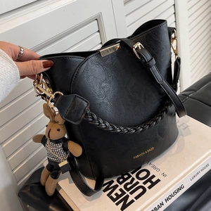 Sac seau rétro en cuir noir à texture litchi avec un charmant pendentif lapin