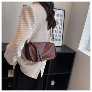 Détail de la bandoulière vintage en cuir marron avec tirette de zip à motif ethnique