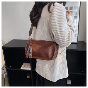 Sac cylindrique marron avec bandoulière à motifs bohèmes et détails de glands en cuir