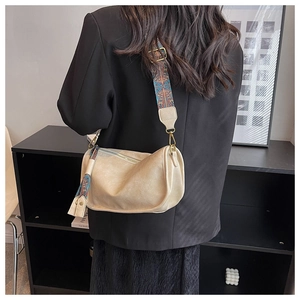 Détail du sac polochon beige avec large bandoulière ethnique et breloque pompon
