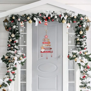 Vertical wooden Christmas tree sign with gnome designs hanging on a festive door wreath