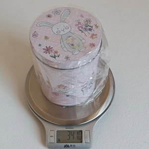 Detailed top view of Easter bunny pink tin box on a digital scale showing 341g weight