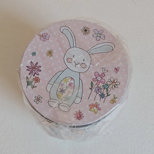 Detailed top view of a pink Easter bunny tin box with colorful floral patterns