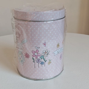 Detail view of pink Easter tin box featuring cartoon rabbit and floral dot patterns