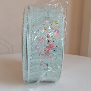 Gros plan sur une boîte en fer blanc avec motifs de lapins de Pâques et pois blancs