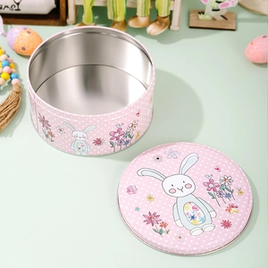 Détail d'une boîte en fer lapin de Pâques rose à pois avec intérieur en métal argenté brillant