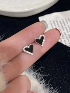 Asymmetric black heart stud earrings with silver borders and sparkling rhinestones