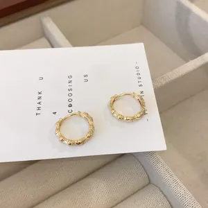 Detail of 18K gold bamboo-style hoop earrings with micro-set diamonds on jewelry tray