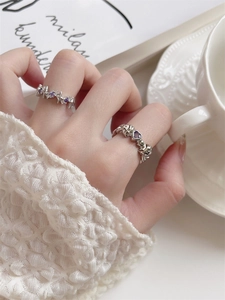 Irregular silver ring set with purple heart crystal and starburst design on a magazine
