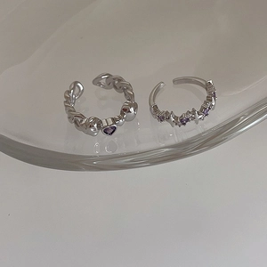 Detail of two-piece silver open rings with purple heart zircon and star motifs