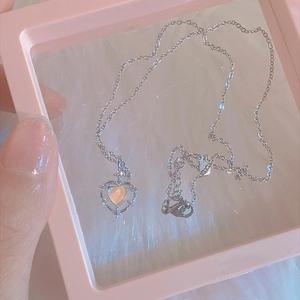 S925 sterling silver heart necklace with iridescent gemstone on white faux fur background