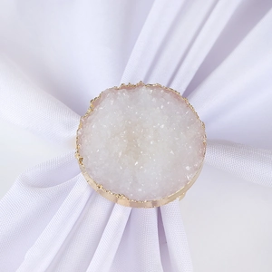 Macro view of crystal druzy napkin ring with pink stone and elegant gold plated edges