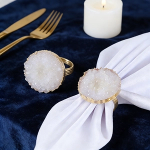 Macro detail of white crystal napkin ring with gold metal base on blue velvet