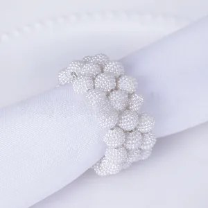 Close-up of a handcrafted white pearl cluster napkin ring for elegant wedding table decor
