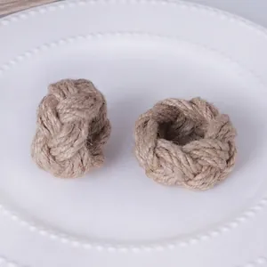 Natural jute woven napkin rings set with braided texture on a white porcelain plate