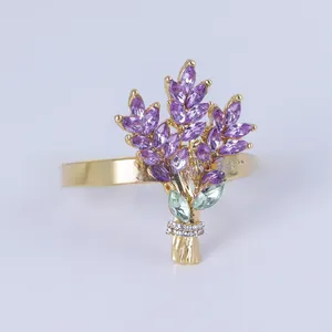 Détail de l'anneau de serviette doré avec fleur en pierre violette et strass élégants