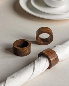Detail view of handcrafted dark wood napkin rings set with natural grain and smooth finish