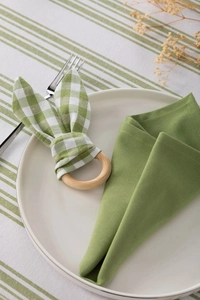 Macro view of wooden napkin ring with green plaid rabbit ears on a table setting