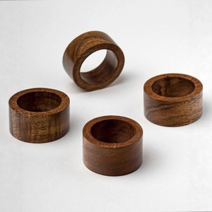 Set of 4 dark brown wooden napkin rings with natural grain on white background