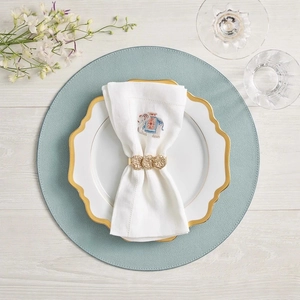 Elegant gold textured napkin ring with elephant embroidery napkin on ceramic dinner plate