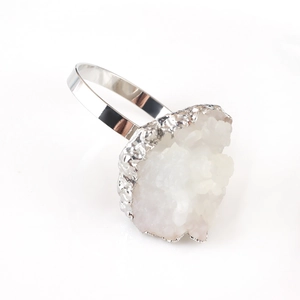Macro shot of silver metal napkin ring featuring white natural quartz cluster crystals