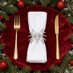 Sparkling silver spider napkin ring with crystals on festive table setting with pine