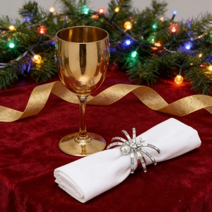 Close-up of a silver spider napkin ring with sparkling rhinestones on a white napkin