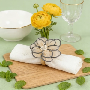Elegant cream organza flower napkin ring with pearl center on woven grass loop holder